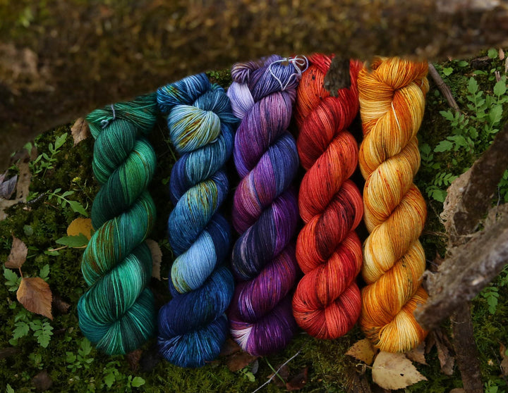 Yarn Skiens in Green, Blue, Purple, Red and Orange lined up from left to right