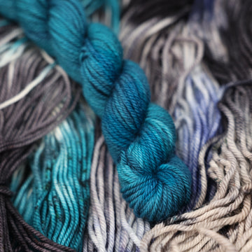 a dark ocean navy blue D-mini yarn on top of unwound black white and blue yarn.