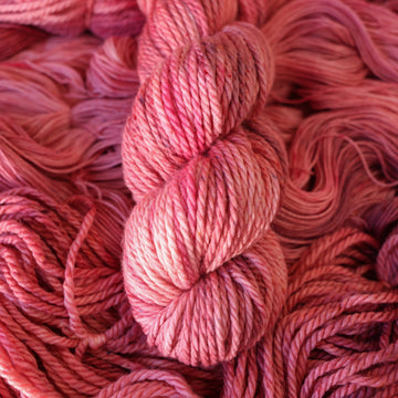 light pink Bulky yarn with more unwound light pink yarn underneath.