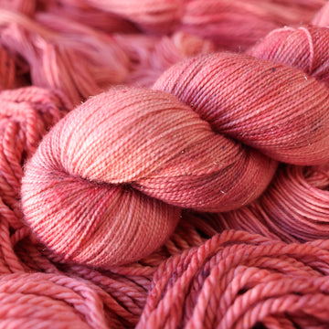 light pink sparkle yarn with more unwound light pink yarn underneath.