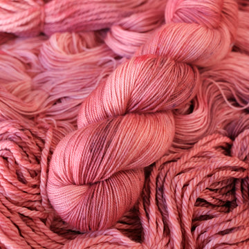 light pink sport yarn with more unwound light pink yarn underneath.