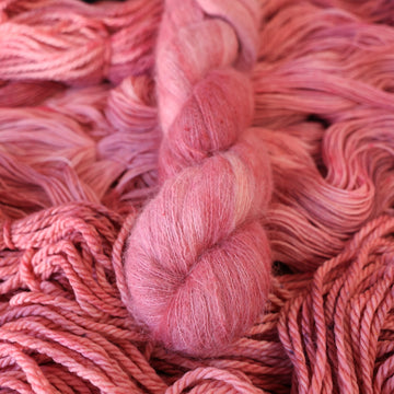 light pink suri yarn with more unwound light pink yarn underneath.