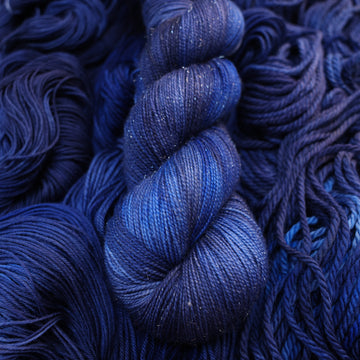 A dark sapphire colored sparkle yarn on top of that same yarn, but its unwound.