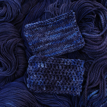 A dark sapphire colored crochet and knit swatches on top of that same yarn, but it's unwound.
