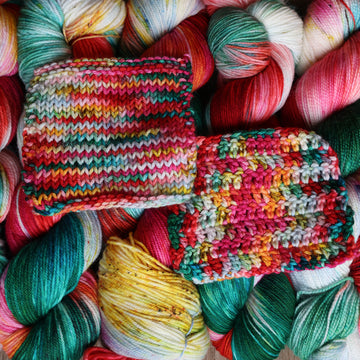 Red, green, light green, white, and yellow crochet and knit swatches on top of the same wound yarn stacked next to each other