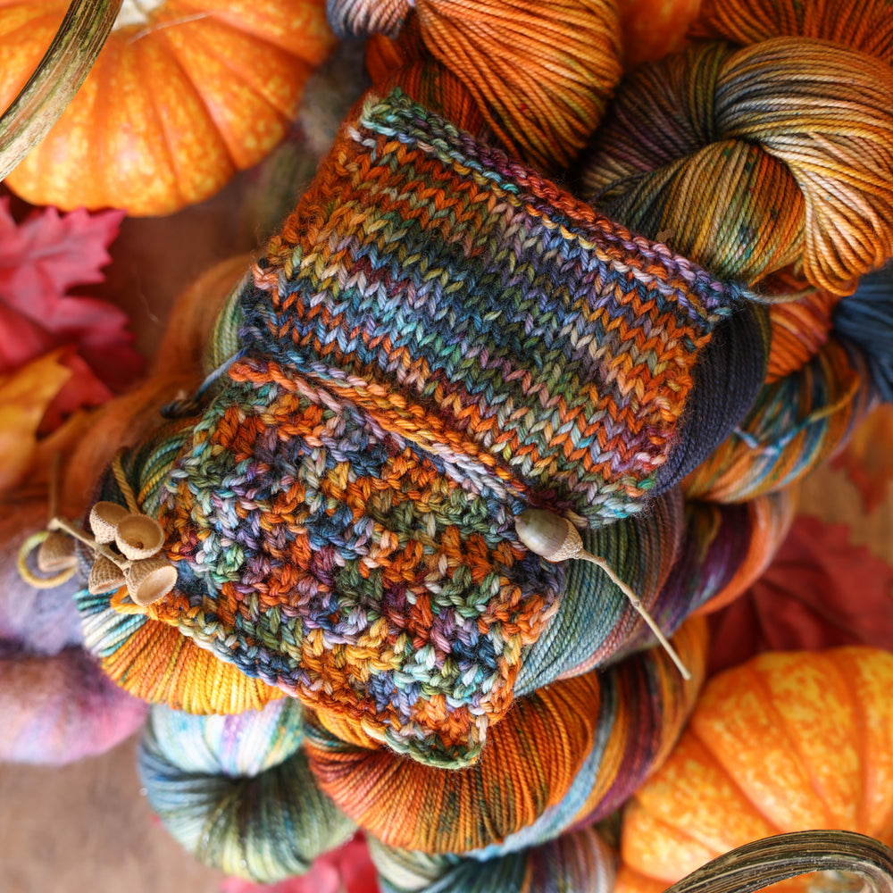 Crochet and Knit swatches of Upstate colorway on table of yarn and fall decor. 