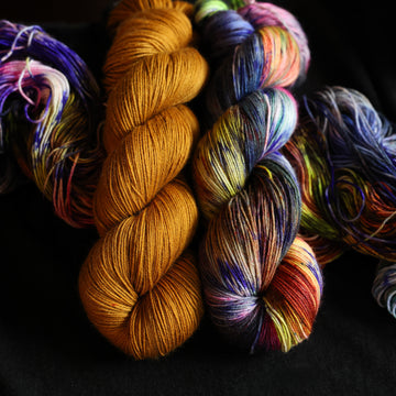 Photo of Jekyll and Hyde Fingering set sitting on top of multicolored yarn.