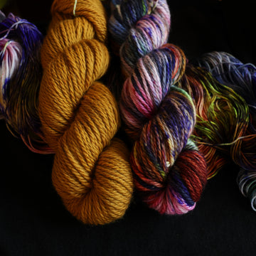 Jeyyll and Hyde Bulky set sitting on top of multicolored yarn.