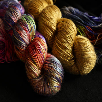 Jeykll and Hyde set sitting on top of multicolored yarn.
