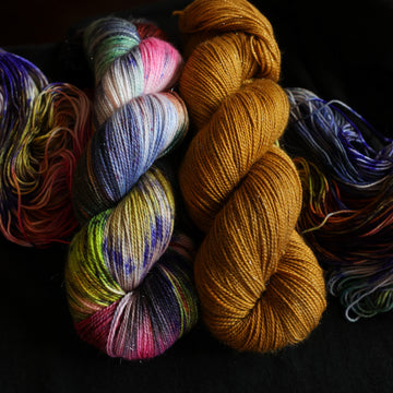 Jekyll and Hyde Sparkle set sitting on top of multicolored yarn.